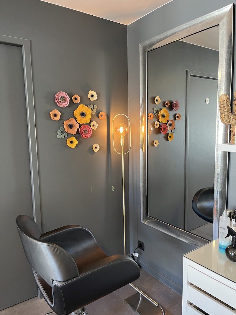 Poste de coiffure élégant avec grand miroir argenté et fauteuil noir chez Carré B